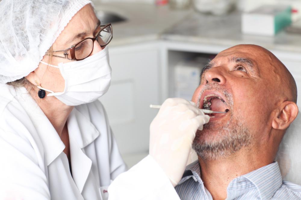 man in dental exam chair receiving dental implant I dental implants pikesville MD